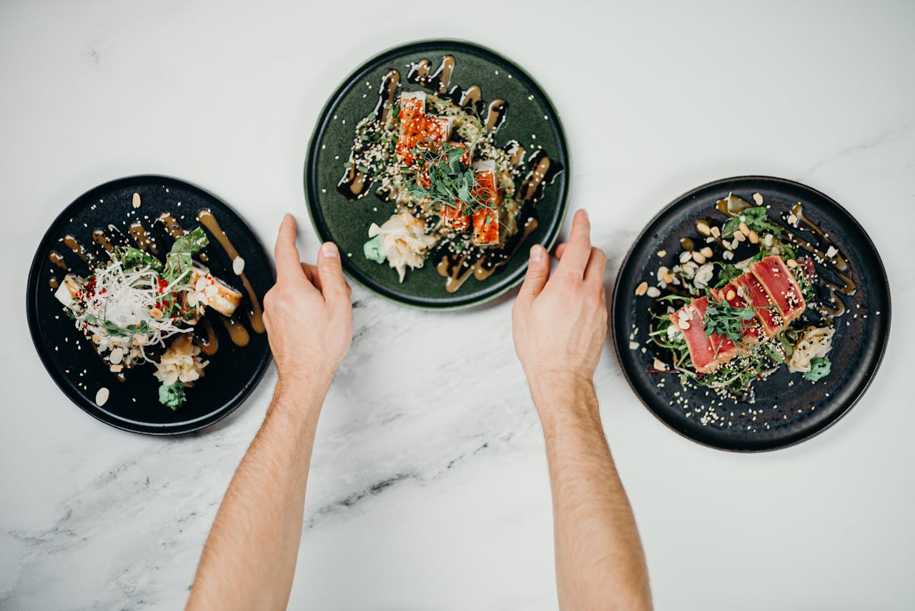 Top view of sushi dishes being served, showcasing a variety of Japanese cuisine on elegant plates.